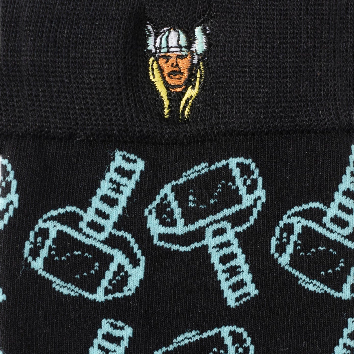 Black beanie with embroidered face design and patterned hammer design on a black background