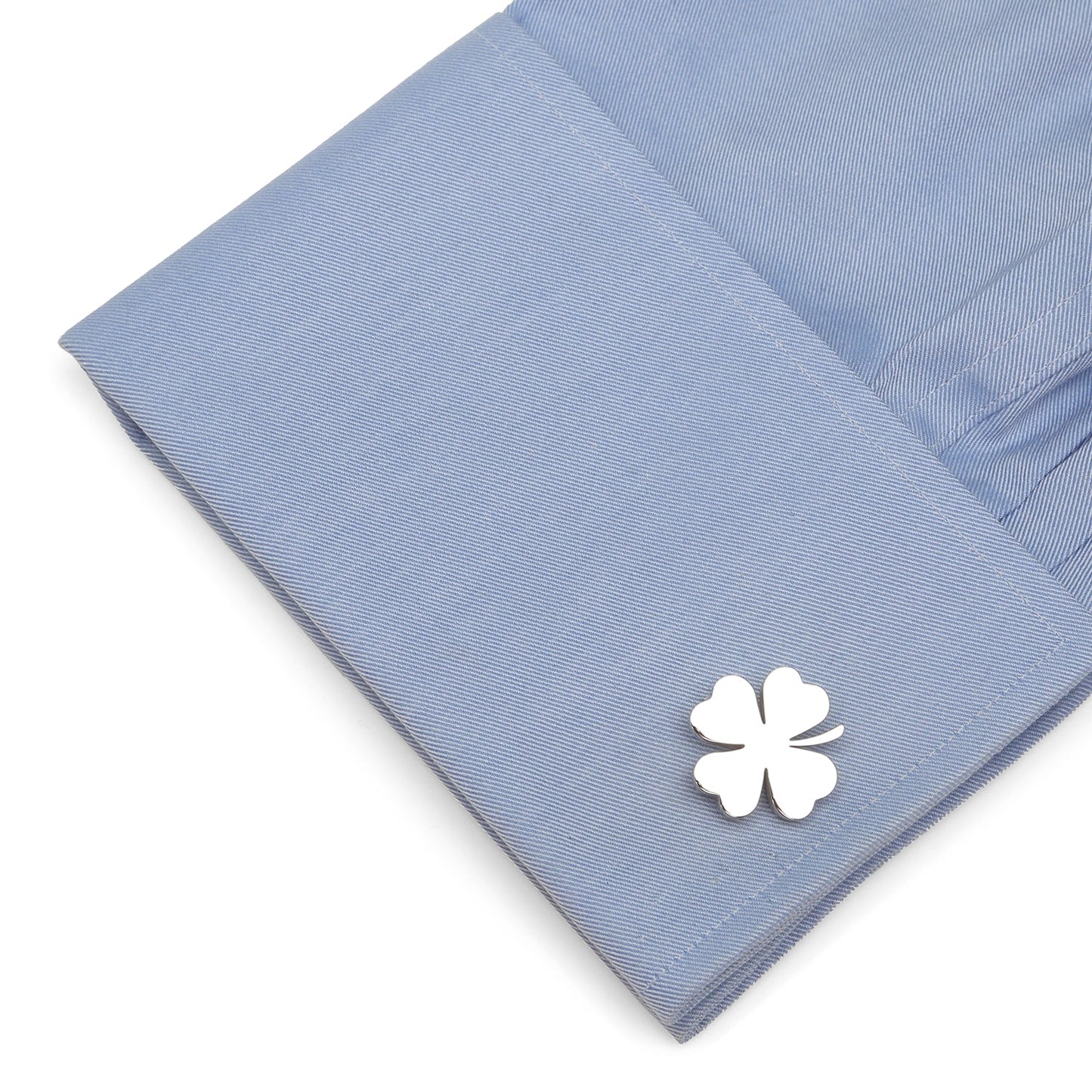 White four-leaf clover cufflink on a blue dress shirt