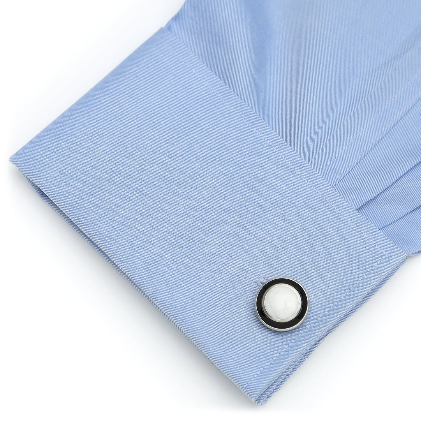 Close-up of a light blue shirt cuff with a button on a white background