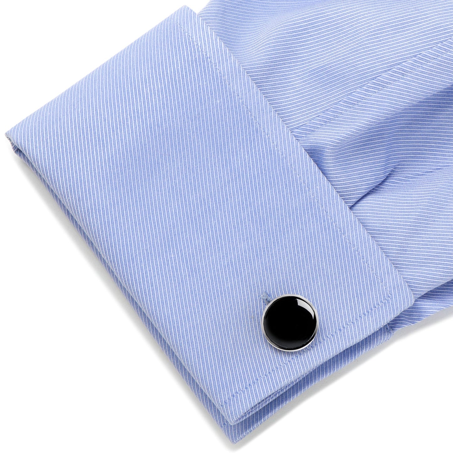Black cufflink on a light blue striped shirt