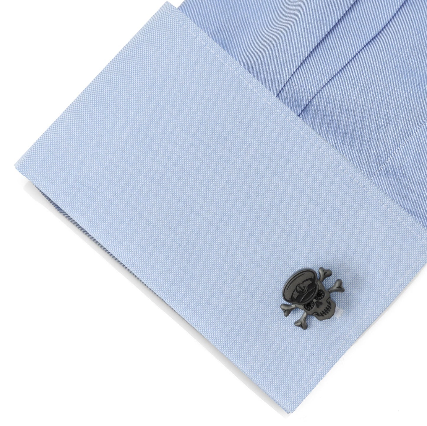 Cufflink on a light blue dress shirt with a white background
