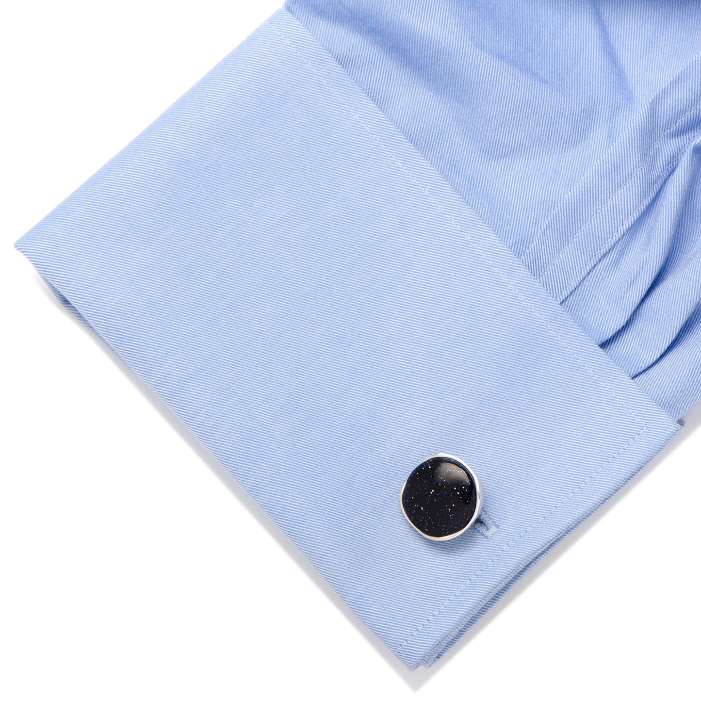 Black cufflink on a light blue shirt cuff
