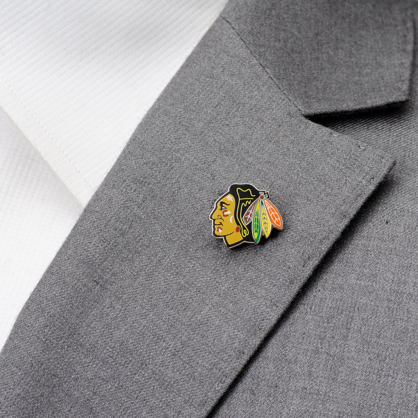 Blackhawks logo pin on a gray suit jacket