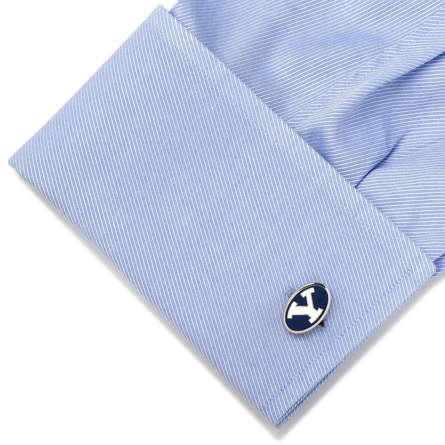 Close-up of a blue shirt cuff with a cufflink on a white background