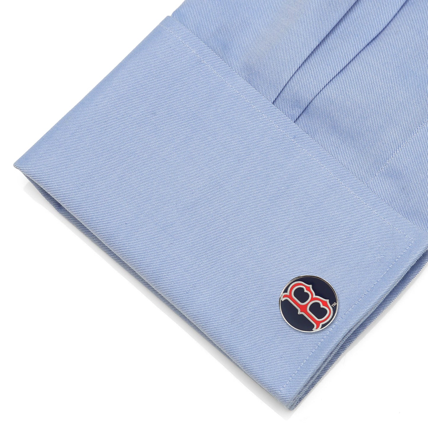 Cufflink with a logo on a light blue shirt