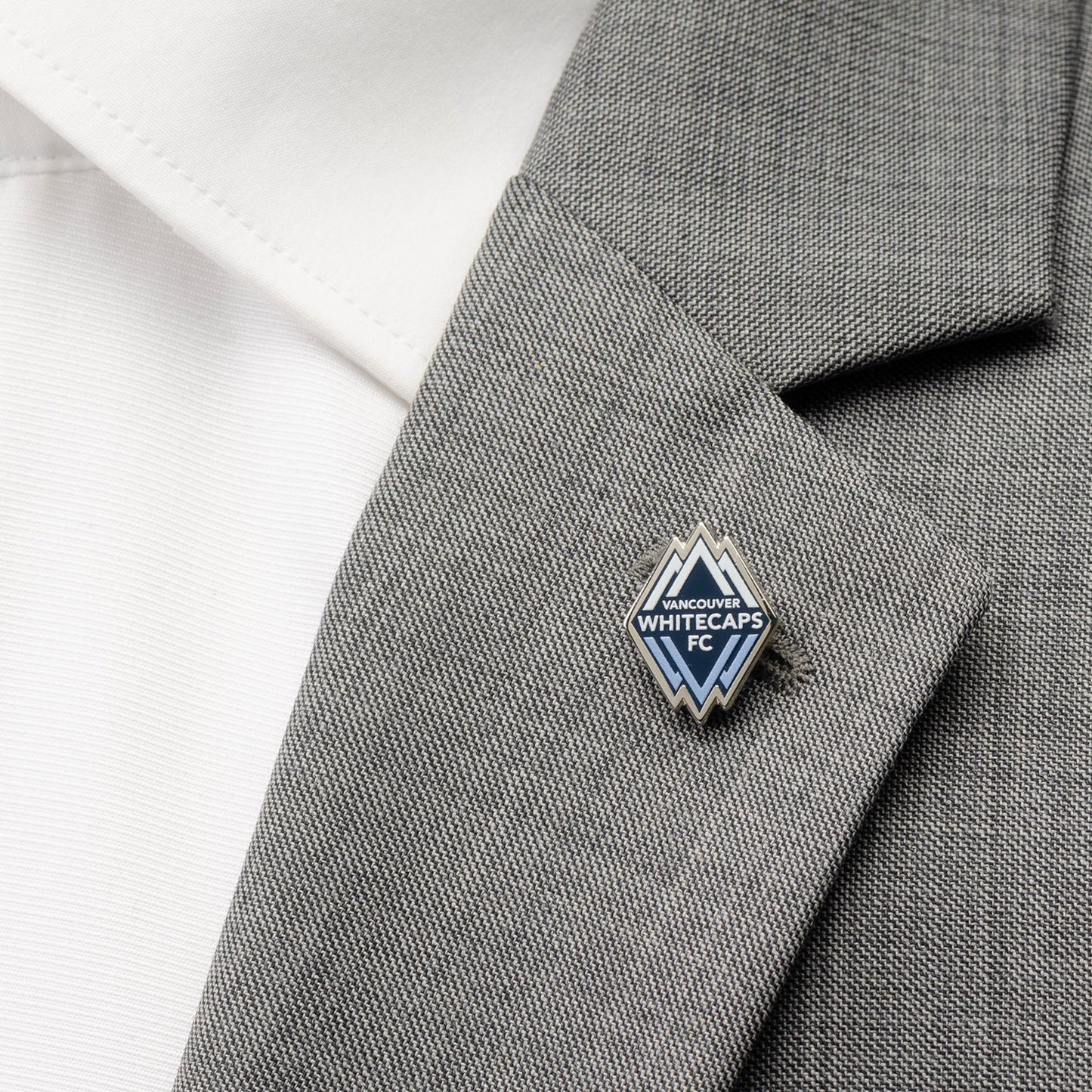 Pin on a gray suit lapel with a white shirt background