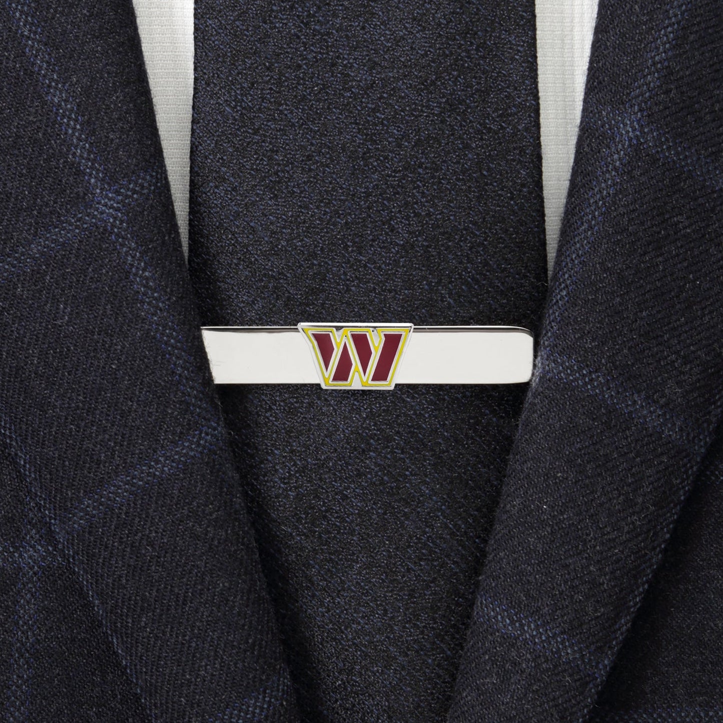 Tie clip with a logo on a suit jacket