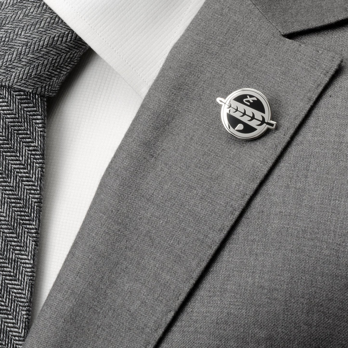 Gray suit jacket with a lapel pin on a white shirt and gray tie.