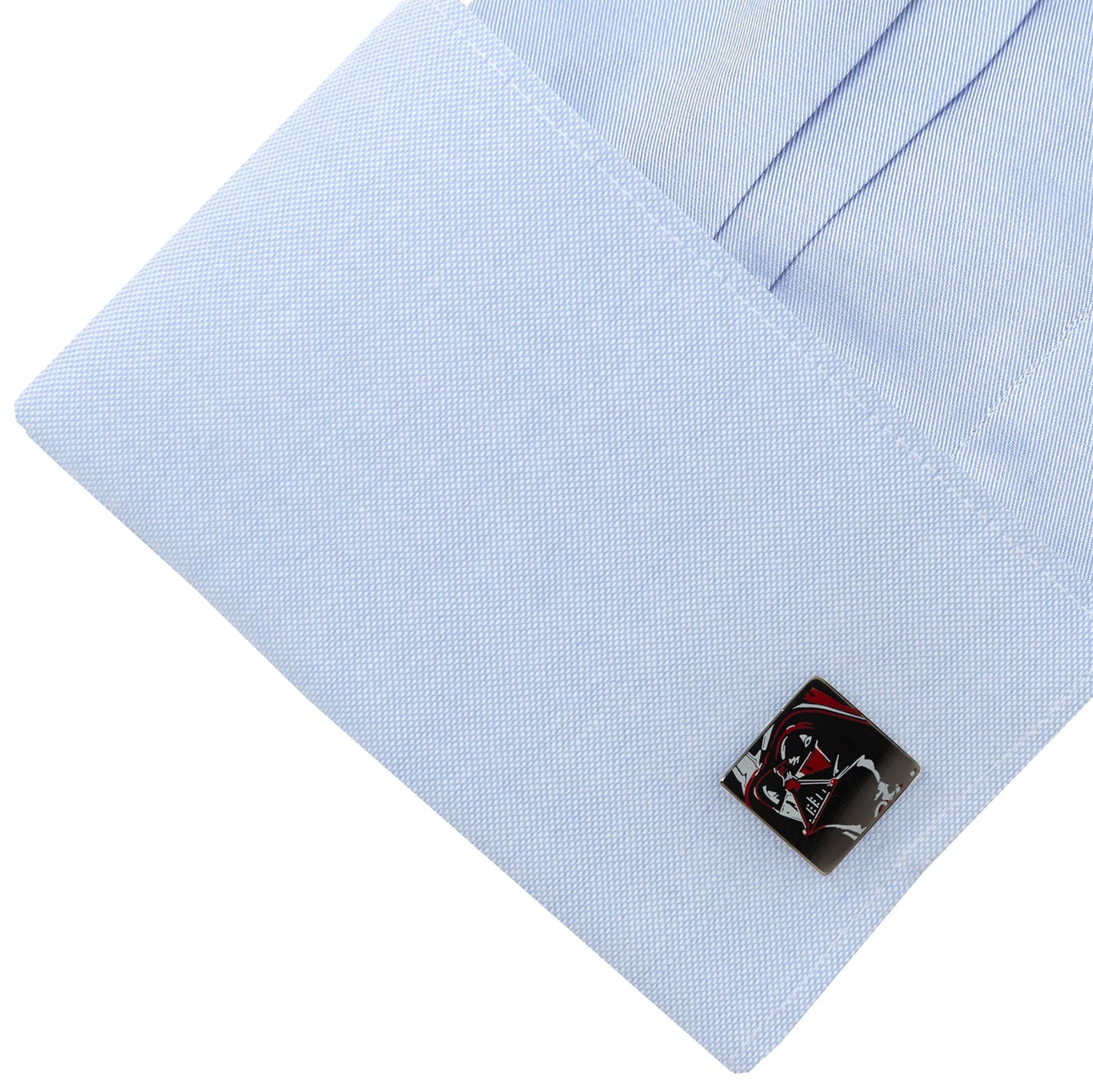 Cufflink on a light blue shirt with a white background