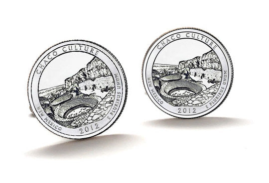 A pair of silver-colored cufflinks featuring an engraved design of the Chaco Culture National Historical Park quarter with a year 2012 inscription.
