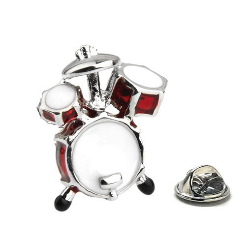 A silver-colored lapel pin shaped like a drum with white and red enamel details, accompanied by a small silver clasp.