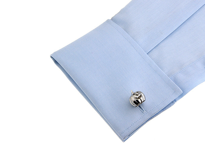 Cufflink on a light blue shirt cuff with a white background