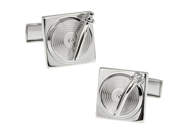 Silver cufflinks designed like turntables on a white background