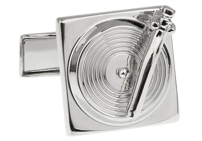 Silver cufflink with a detailed design on a white background
