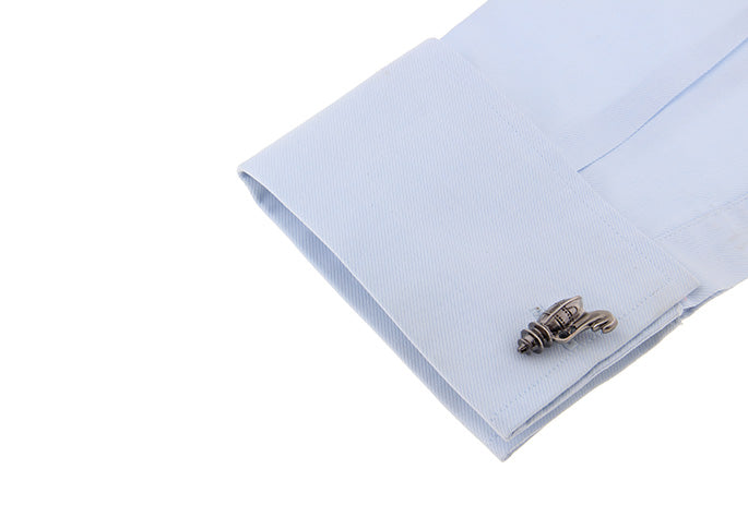 Cufflink on a light blue pocket square with a white background