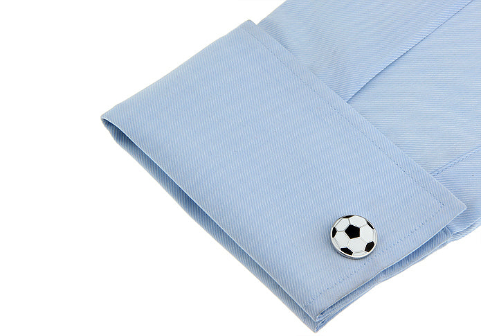Light blue shirt cuff with a soccer ball cufflink on a white background