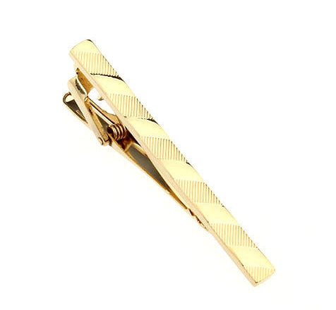 Gold tie clip on a white background
