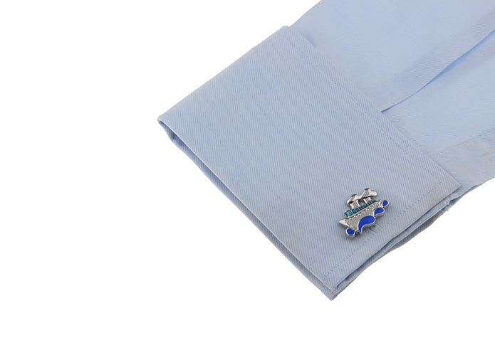Cufflink on a light blue shirt sleeve with a white background