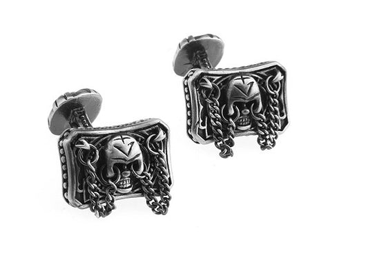 Pair of silver skull-themed earrings on a white background