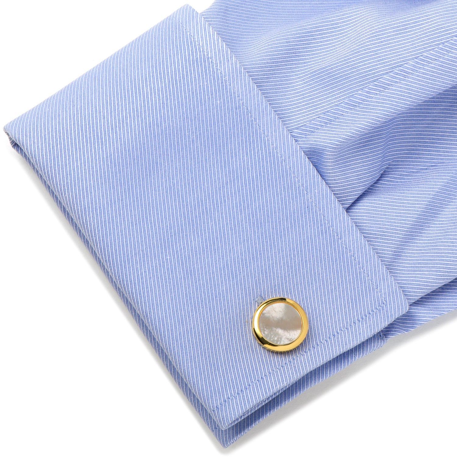 Close-up of a blue striped shirt cuff with a gold button on a white background