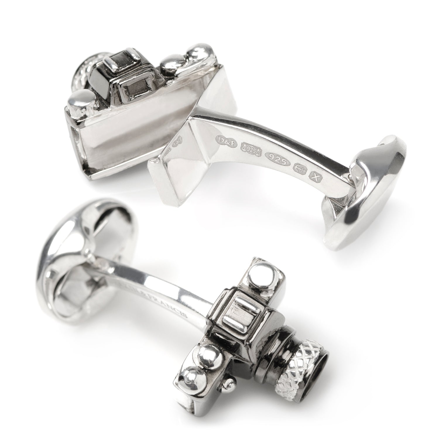 Silver cufflinks with intricate design on a white background
