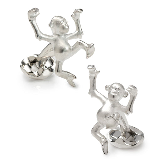 Silver monkey cufflinks on a white background