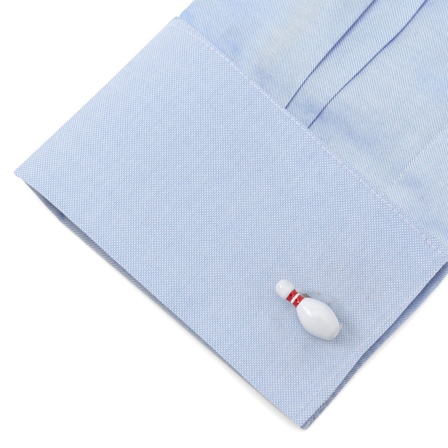 Light blue dress shirt with a unique cufflink shaped like a bowling pin on a white background