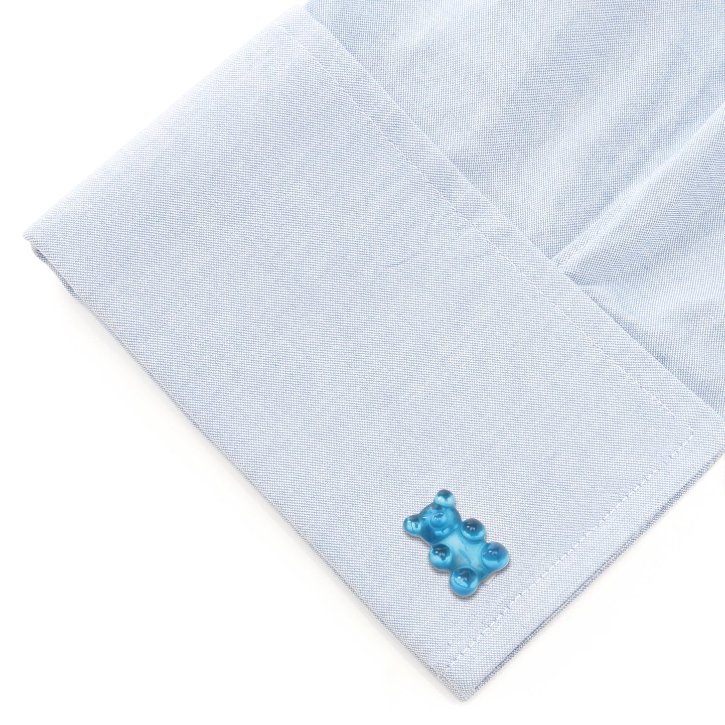 Light blue pocket square with a blue bear-shaped cufflink on a white background