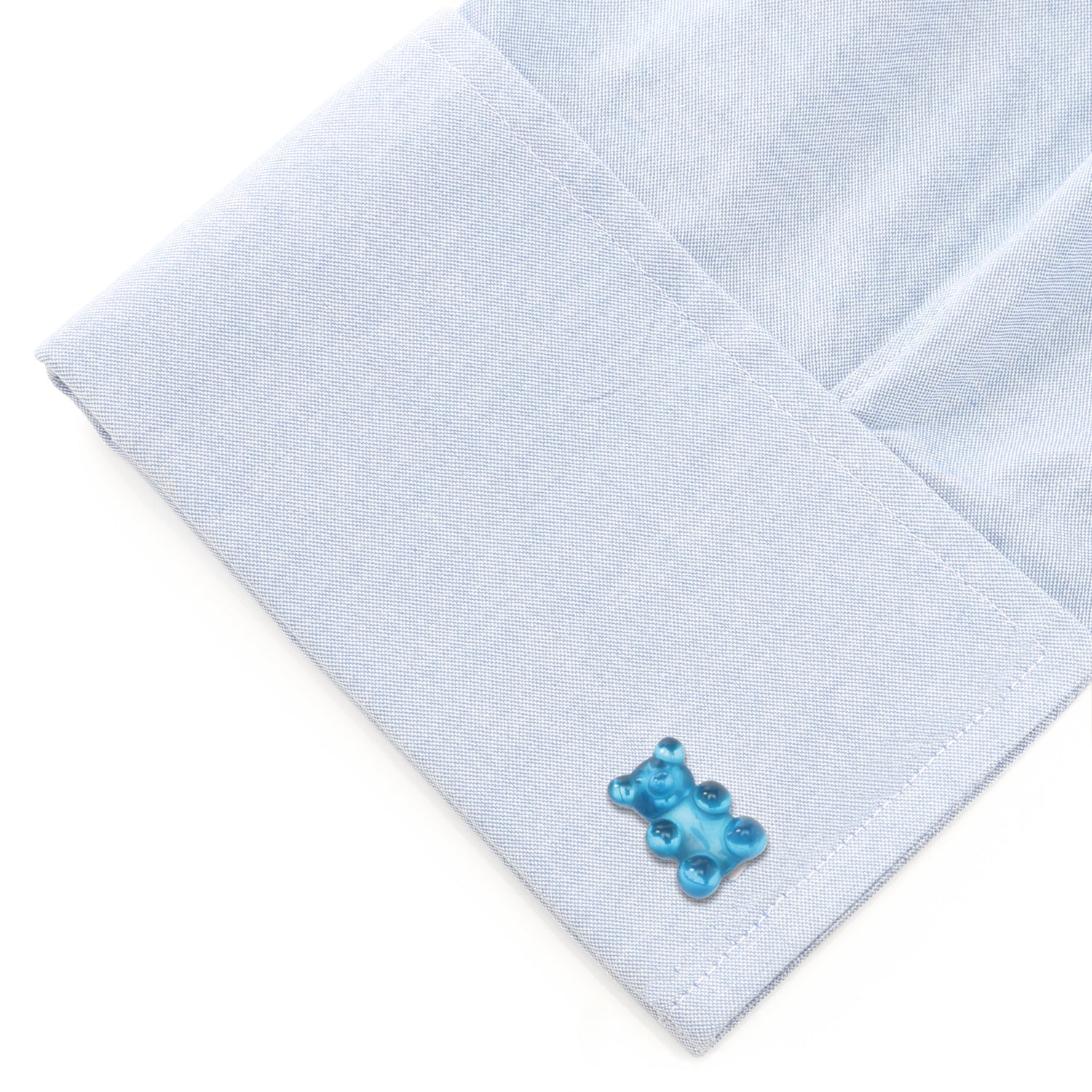 Light blue pocket square with a blue bear-shaped cufflink on a white background
