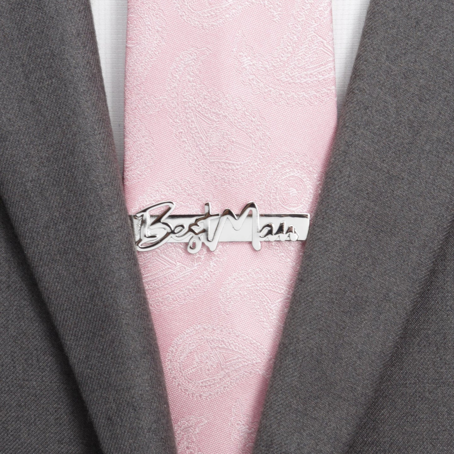 Pink tie with a 'Best Man' tie clip on a gray suit jacket