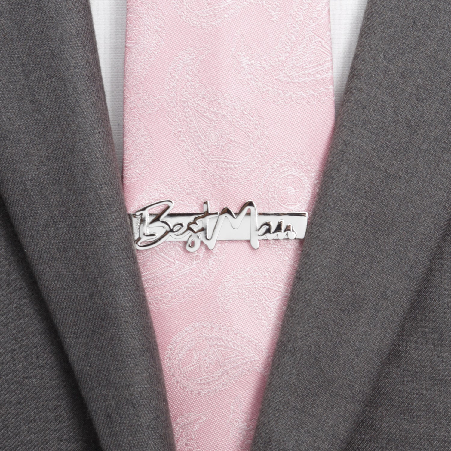 Pink tie with a 'Best Man' tie clip on a gray suit jacket