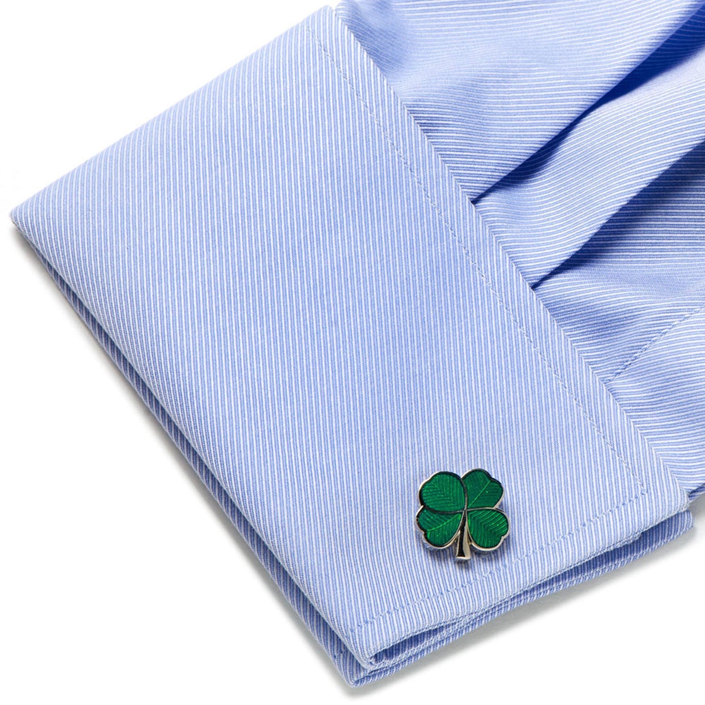 Green four-leaf clover cufflink on a light blue striped shirt