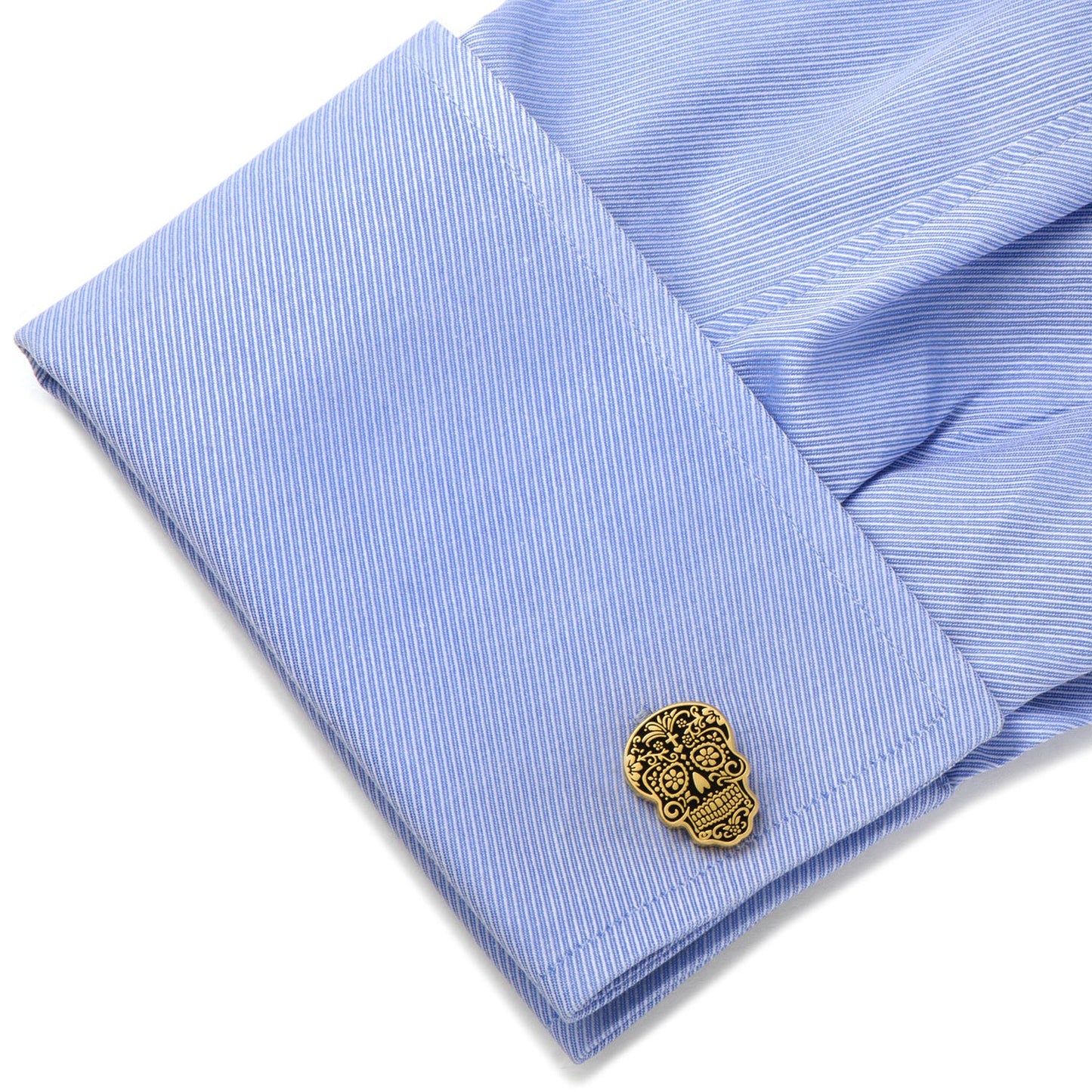 Gold skull cufflink on a blue striped shirt