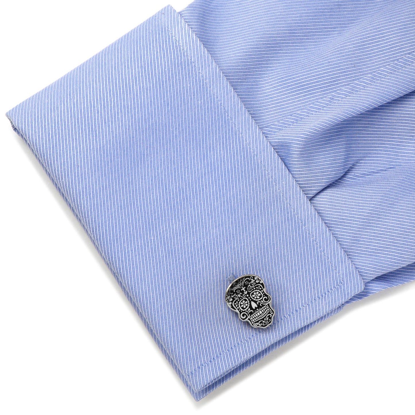 Blue striped shirt with a skull design cufflink on a white background