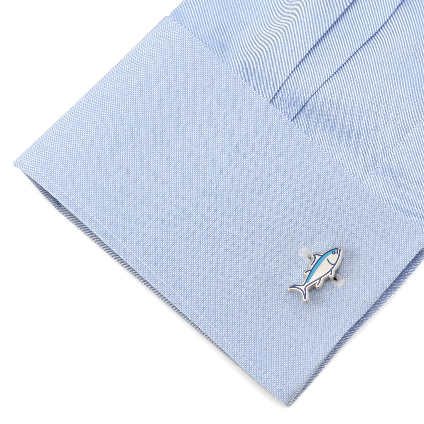 Fish-shaped cufflink on a light blue dress shirt