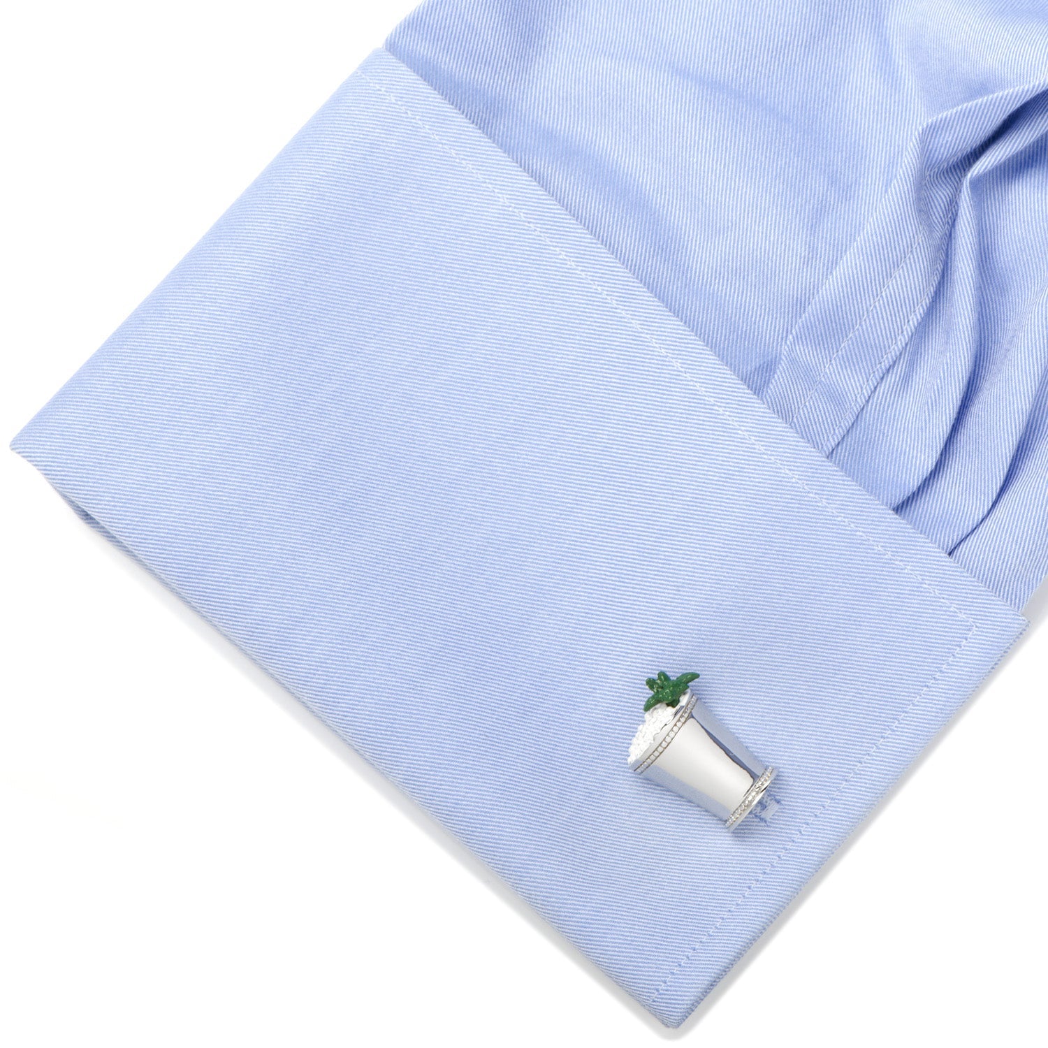 Cufflinks with a small plant design on a light blue fabric background