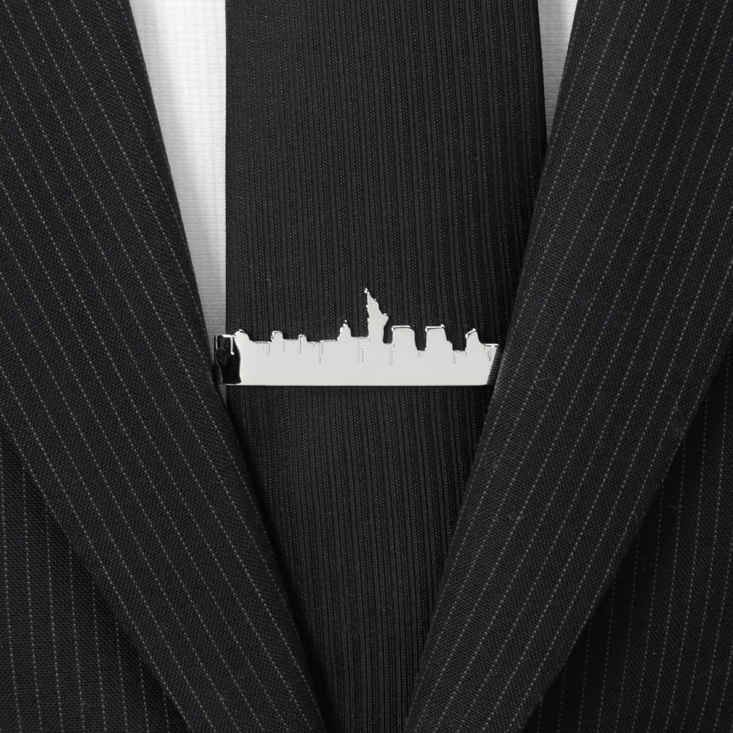 Black pinstripe suit with a silver tie clip featuring a city skyline.