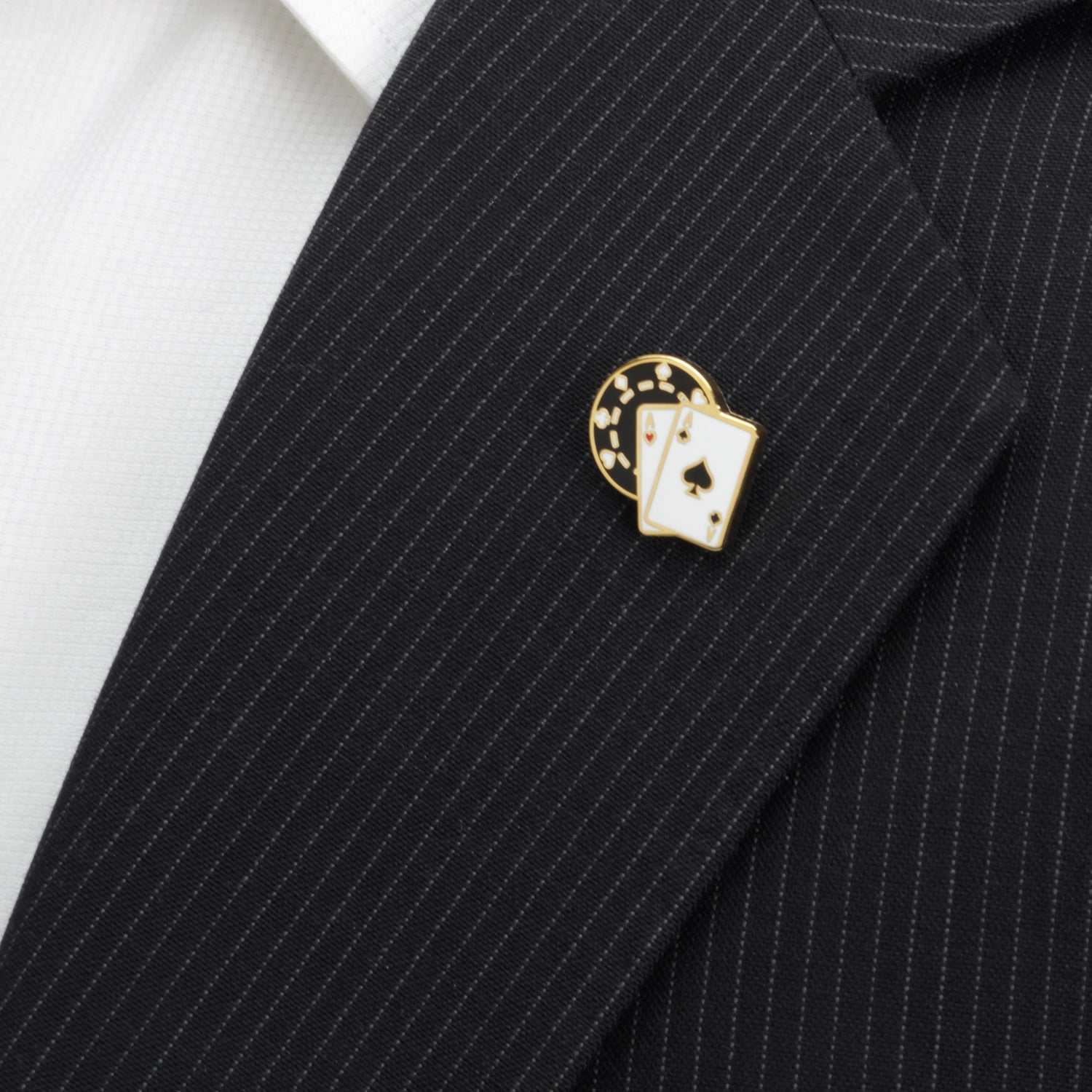 Black pinstripe suit with a decorative lapel pin featuring playing cards.