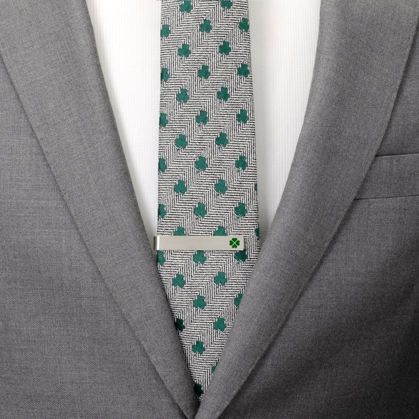 Gray suit jacket with a patterned tie and silver tie clip.