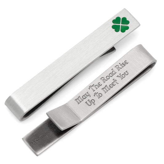 Silver tie clip with engraved text and clover leaf on a white background