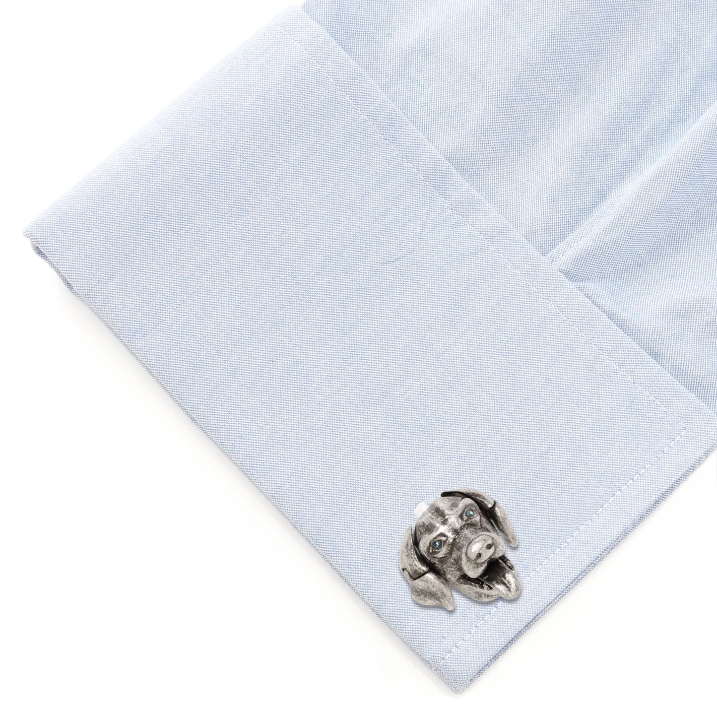 Cufflink on a light blue dress shirt with a white background