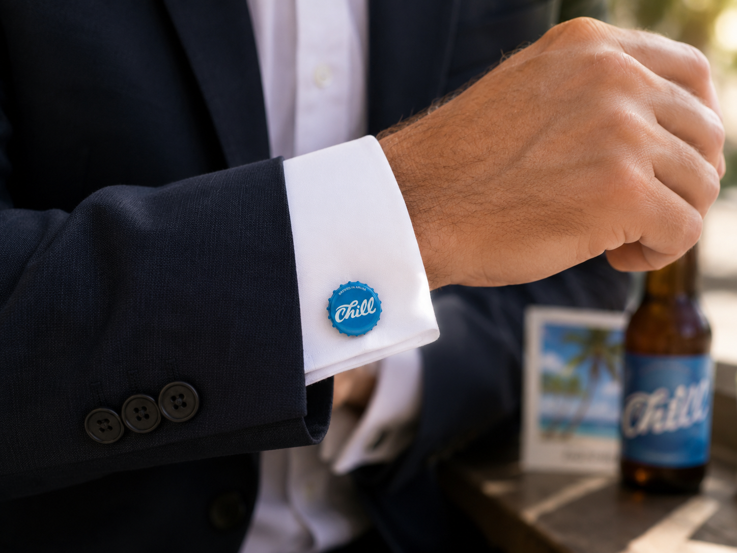 Man wearing authentic Aruba Chill Beer bottle cap cufflinks with a navy business suit and white dress shirt.