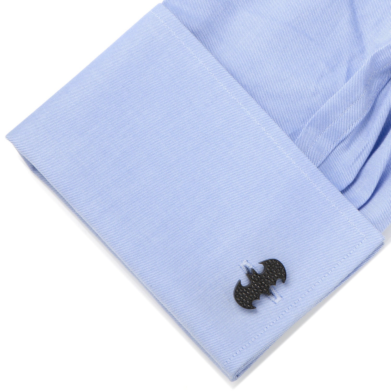 Close-up of a light blue shirt with a black and white embroidered design on a white background