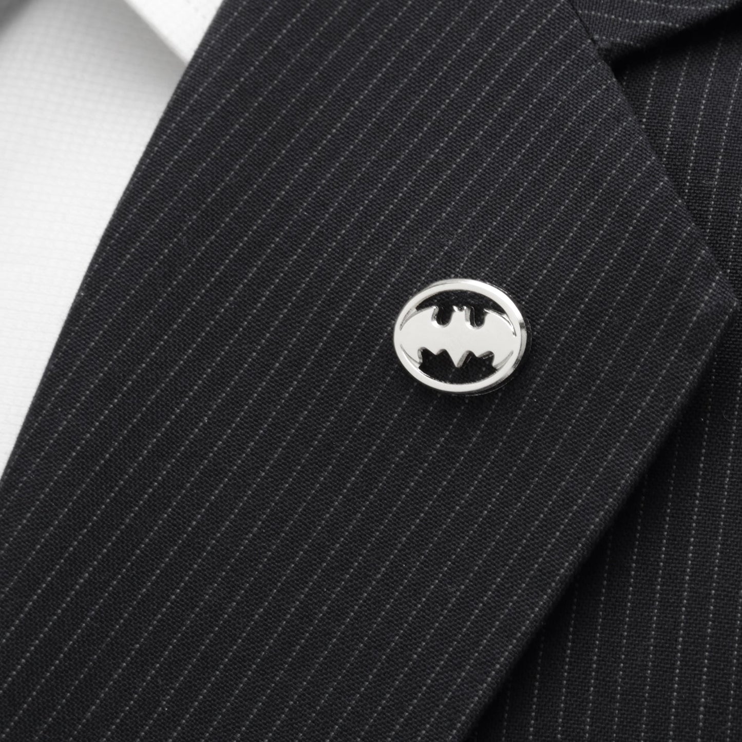 Black pinstripe suit jacket with a Batman logo pin on a white background