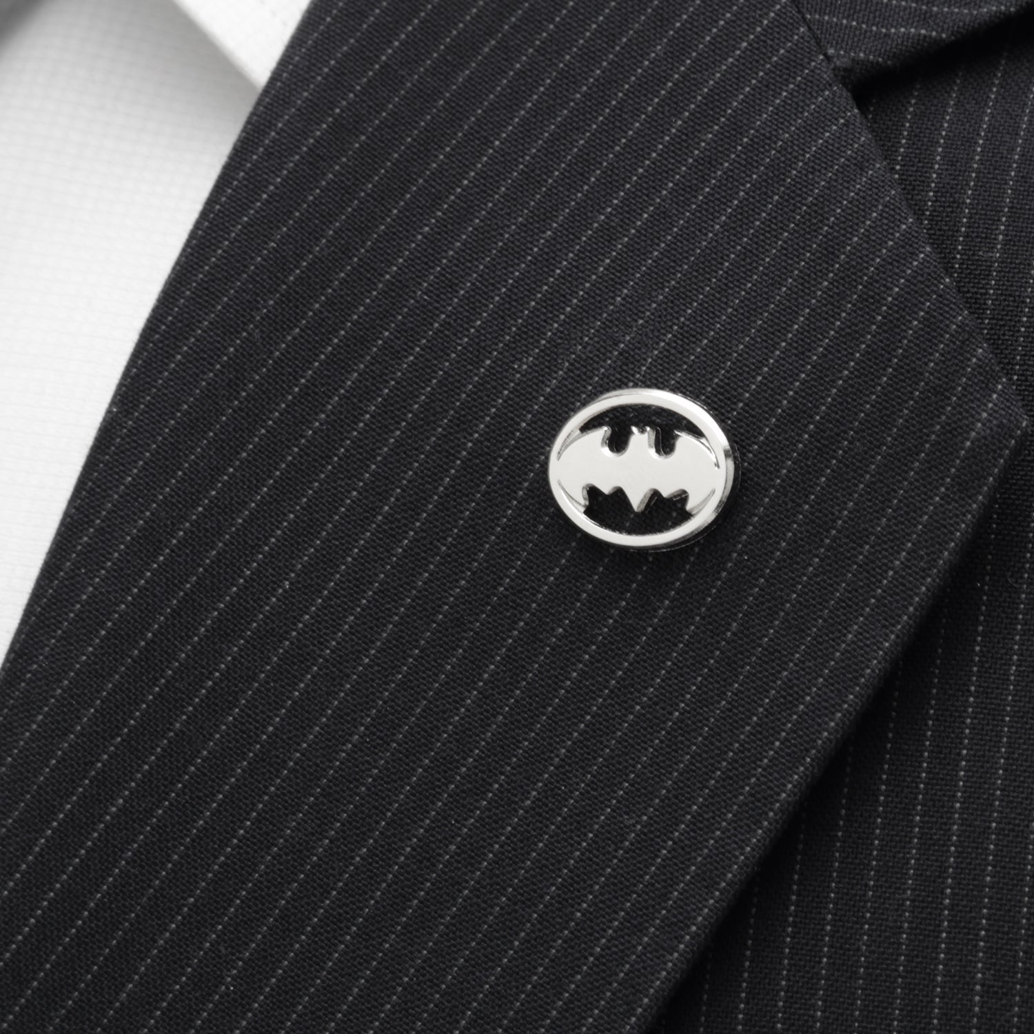 Black pinstripe suit jacket with a Batman logo pin on a white background