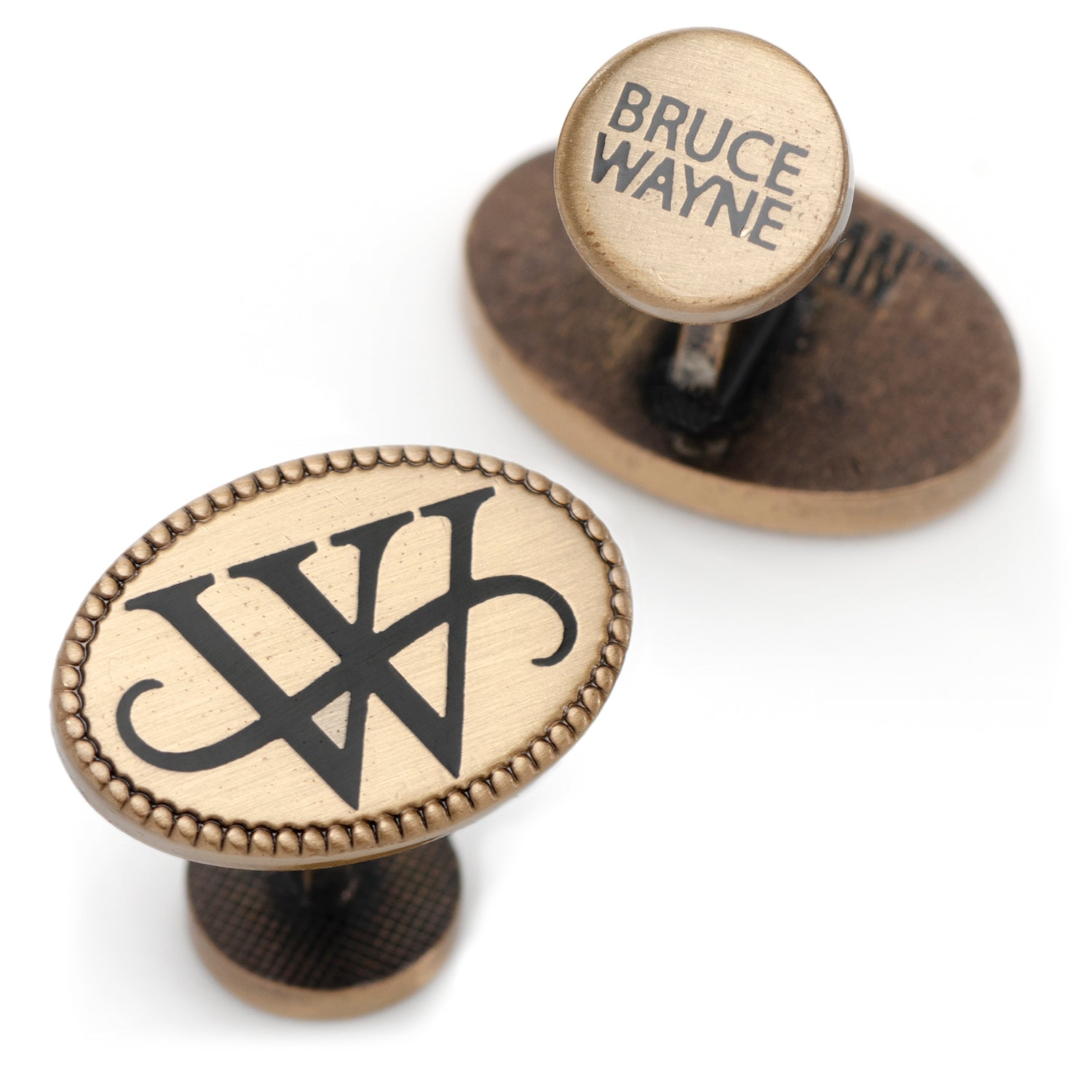Bronze door handles with 'Bruce Wayne' engraving on a white background