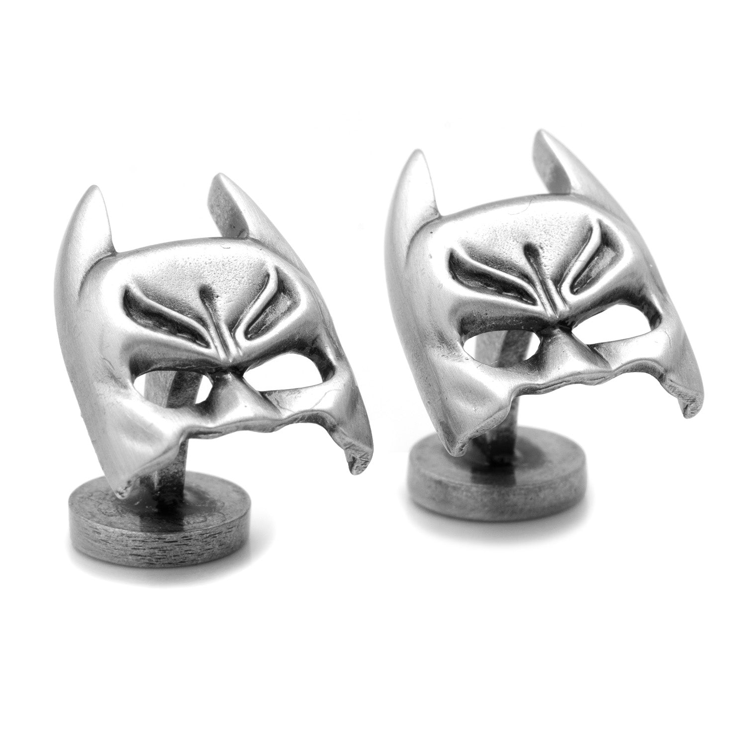 Silver mask-shaped cufflinks on a white background