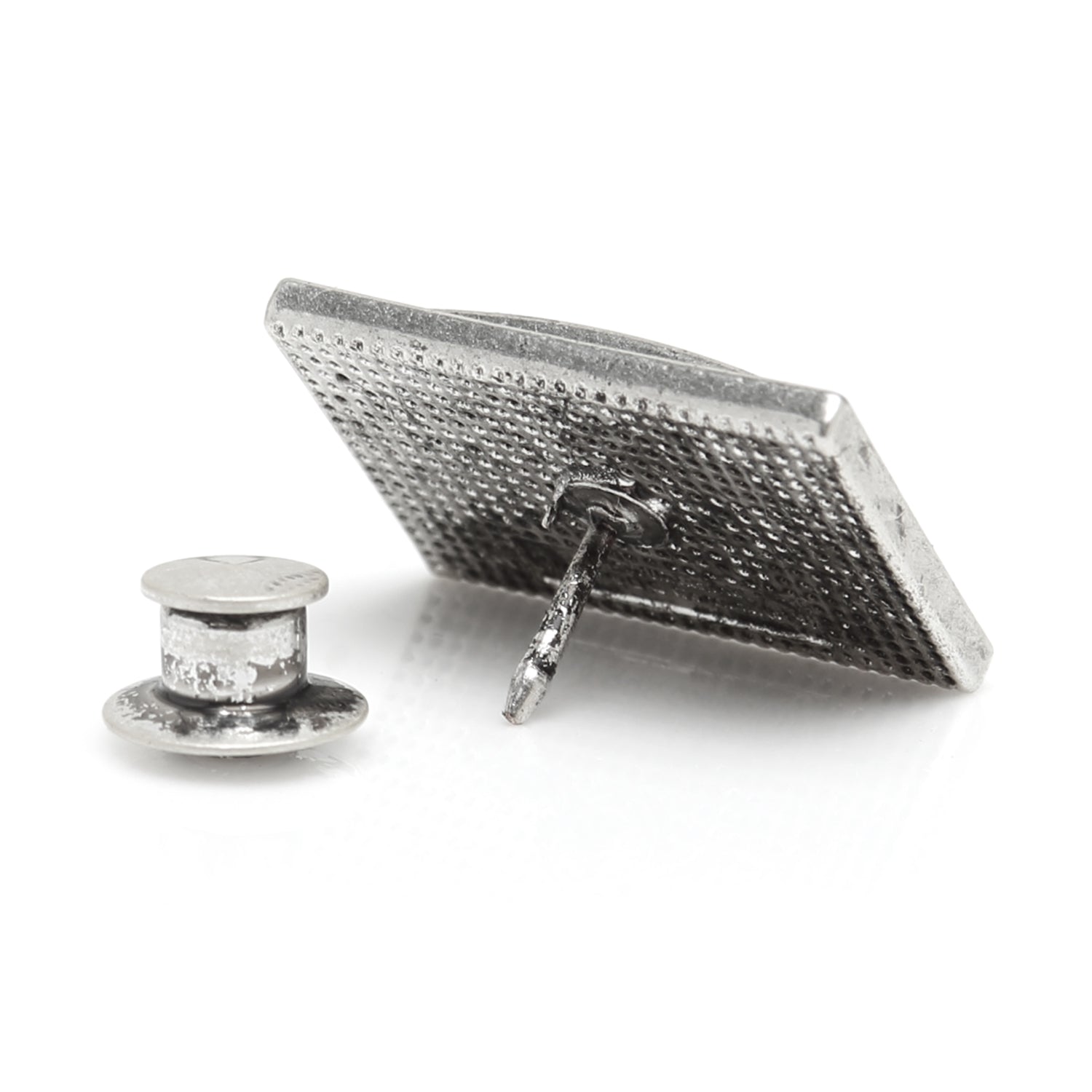 Silver textured square brooch on a white background