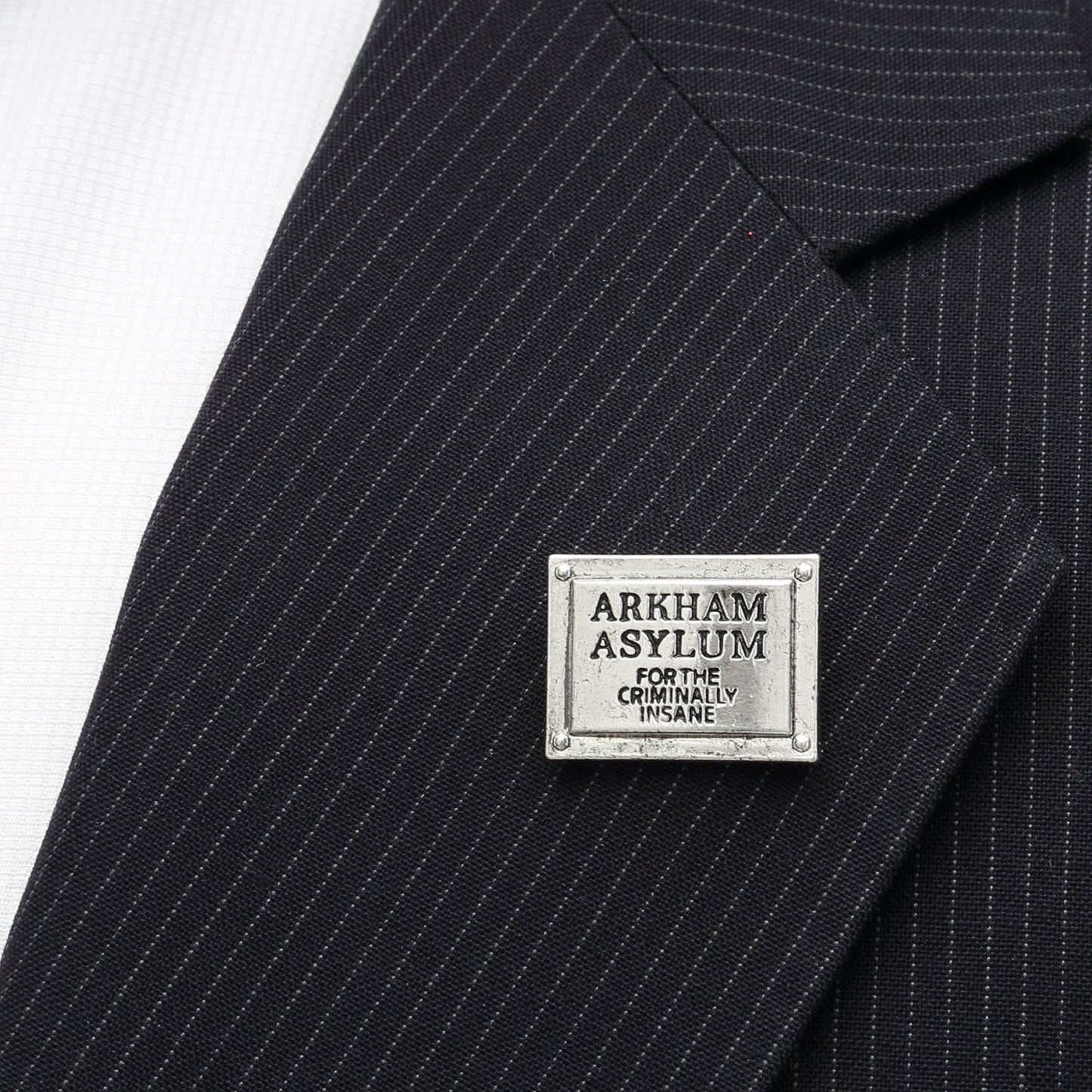 Black pinstripe suit with 'Arkham Asylum' label on a white background