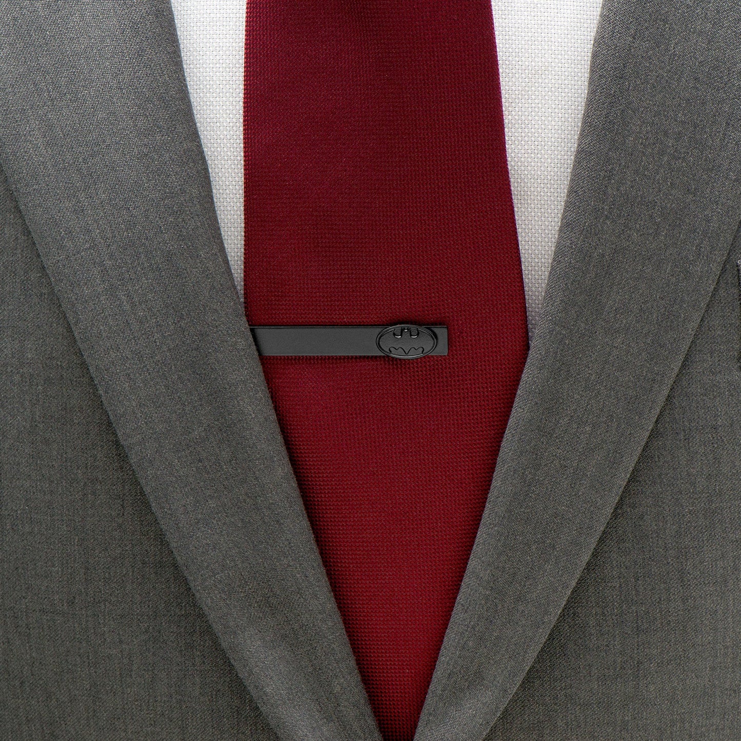 Gray suit jacket with a red tie and gray tie clip on a white background